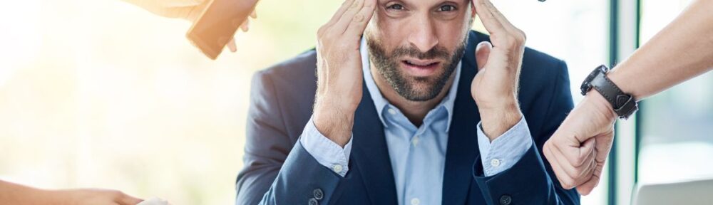 A man in blue suit overwhelmed by requests and tasks